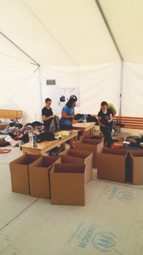 Sorting boxes of clothing donations for refugees.